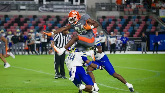 Running back Coco Brown hurdles a pair of defenders on his way to a 62-yard touchdown run
