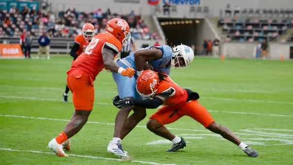 Two Bearkat defenders tackle a FIU receiver
