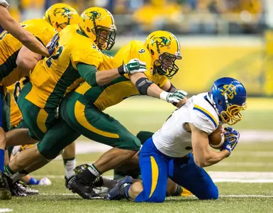 Travis Beck (52) and Esley Thorton (9) tackle