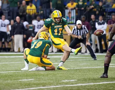 Adam Keller (17) kicks from the hold of Ben LeCompte
