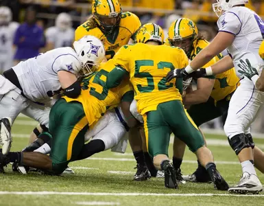 Jeremy Gordon (95) and Travis Beck (52) lead the tackle.