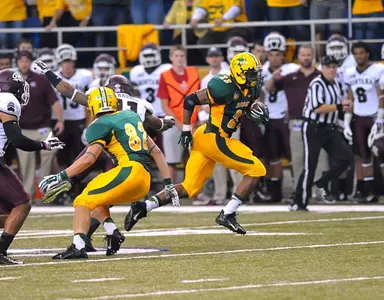 John Crockett (23) runs past the block of Zach Vraa (82)