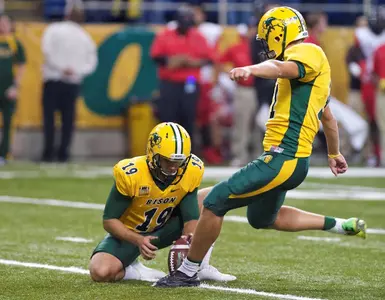 Tom Barneson (31) kicks, Ben LeCompte (19) holds