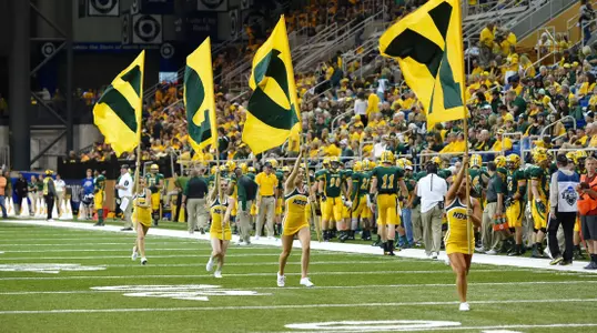 The Bison cheer team runs the NDSU flags