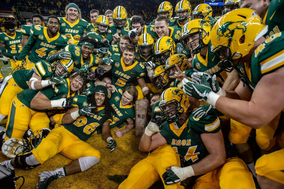 NDSU football team poses with the Dakota Marker