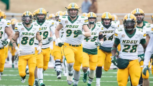 Spencer Waege runs onto the field with teammates