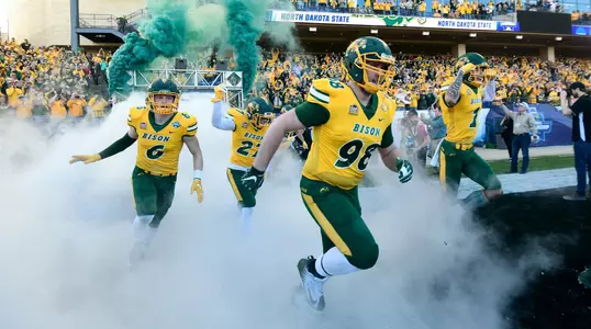 NDSU football players enter Toyota Stadium through smoke
