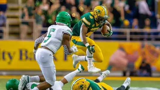 Dimitri Williams leaps over a tackler