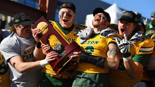 NDSU's Jaxon Brown and Noah Gindorff hold the NCAA football championship trophy.