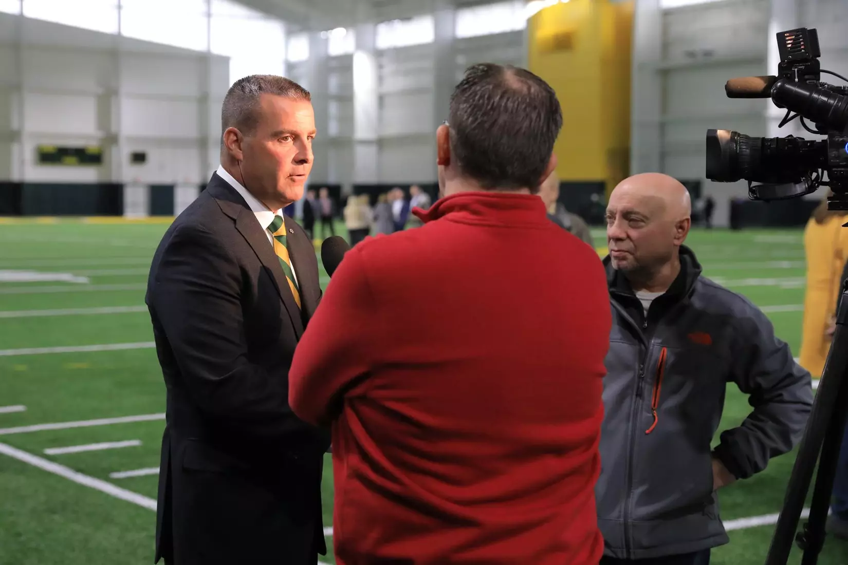 NDSU athletic director Matt Larsen interviews with WDAY TV's Dom Izzo and The Forum's Jeff Kolpack after the ribbon cutting for the Nodak Insurance Football Performance Complex.