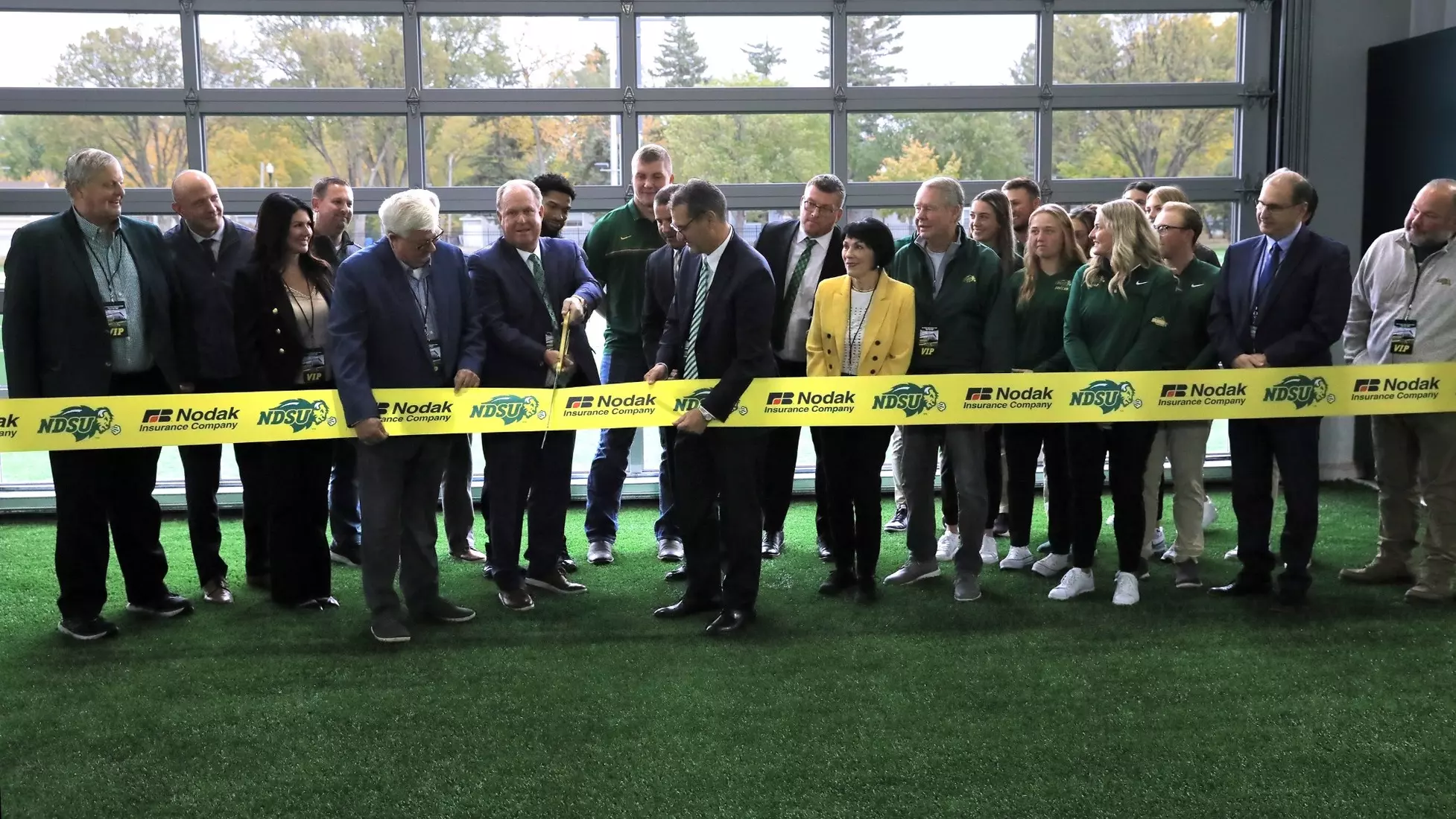Jim Alexander of Nodak Insurance Company cuts the ribbon for the Nodak Insurance Football Performance Complex.