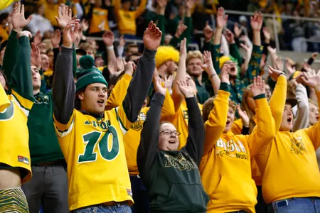 Bison football fans with their hands up