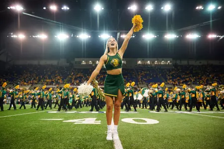 NDSU dance team member on field during a band performance