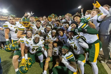 NDSU football players pose with the Dakota Marker
