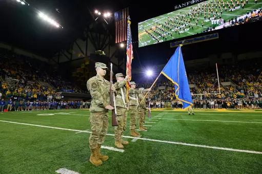 Members of the NDSU Color Guard present flags for the national anthem at a football game.