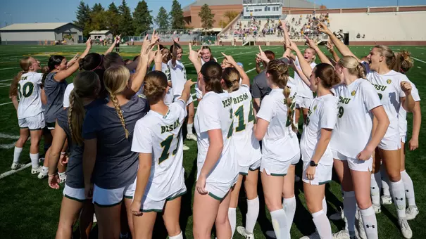 Women's Soccer Huddle Horns Up