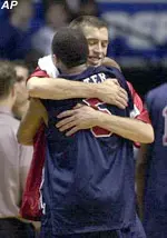 Demetrius Porter hugs teammate Travis DeManby as the team leaves the court after defeating California 82-70 in the first round.