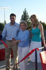 Bulldog men's tennis coach Jay Udwadia, Della Wathen and her granddaughter, Sarah, cut the ribbon for the new lights at the Wathen Tennis Center.