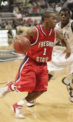 Dishing out six assists in the game, Fresno State guard Kevin Bell drives around Hawaii guard Deonte Tatum during the first half (AP Photo/Marco Garcia).