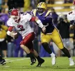 Fresno State quarterback Sean Norton (3) scrambles away from Louisiana State University defender Tyson Jackson (93) in Tiger Stadium in the first half. (AP Photo/Bill Haber)