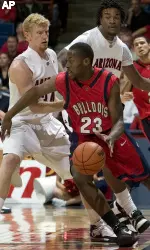 Fresno States' Bryan Harvey (23) tries to dribble through the pressing defense of Arizona's Chase Budinger, left, and Jordan Hill, top, at half-court during the first half. (AP Photo/John Miller)