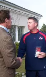 Assistant coach Pat Waer presents a baseball signed by the 2008 National Champions to Governor Schwarzenegger.
