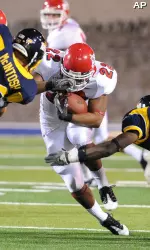 Fresno State's Anthony Harding (22) carries the between Toledo defenders Damien McIntosh, left, and Kenny Veal (9) during the first half. (AP Photo/J.D. Pooley)