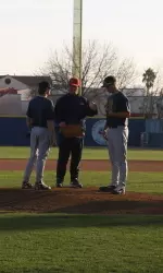 Coach Batesole gives some pointers to a couple of pitchers on the first day of practice.