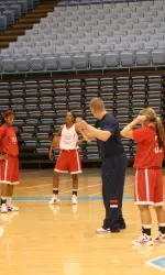 Head coach Adrian Wiggins running practice on Friday night at the Dean Smith Center.