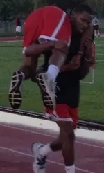 Garrett Johnson carries teammate Aaron Anderson during a Tuesday morning boot camp exercise.