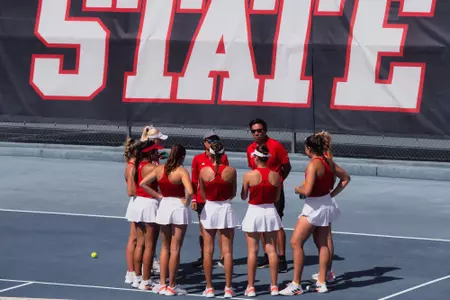 Team huddle, State in background, vs. FPU