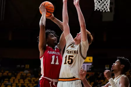 Jan 31, 2023; Laramie, WY, USA; Fresno State Bulldogs forward Isaih Moore (11) shoots against Wyoming Cowboys forward Nate Barnhart (15) at Arena-Auditorium. Mandatory Credit: Troy Babbitt-UW Media-Athletics