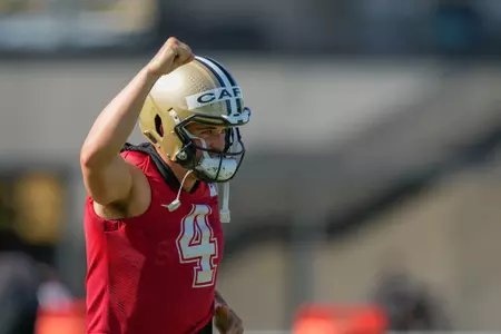 New Orleans Saints quarterback Derek Carr (4) responds the the fans in attendance as he arrives on the field for practice during the Back Together Weekend fan appreciation initiative at the NFL team's football training camp in Metairie, La., Saturday, July 29, 2023. (AP Photo/Gerald Herbert)