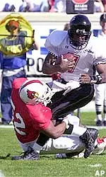 Louisville's Rashad Harris bringing down Cincinnati quarterback Deontey Kenner.