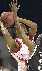 Reece Gaines looks to pass over defensive pressure from Eastern Kentucky player Mike Scott in the 104-63 rout on Tuesday.