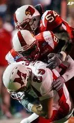 Louisville defenders Robert McCune and Brandon Johnson gang tackle a Miami receiver.