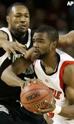 Perrin Johnson looks for a teammate to pass to as Chicago State's Camron Clay provides the defense during the first half. (AP PhotoEd Reinke)