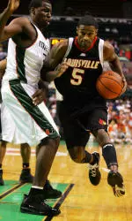 Taquan Dean drives the ball past Miami's Gary Hamilton during the first half.