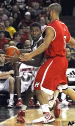 Terrence Williams looks around Hartford's Michael Turner during the second half. Williams finished the game with 14 points, 12 rebounds and 13 assists. (AP Photo/Timothy D. Easley)
