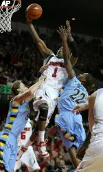 Terrence Williams shoots the ball while defended by Dan Fitzgerald and Jerel McNeal of Marquette during the game at Freedom Hall.