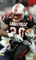 Victor Anderson breaks away from a West Virginia defender as he carries the ball on a 40-yard run during the first half.