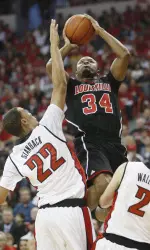 Jerry Smith, center, shoots over UNLV's Chace Stanback, left, and Kendall Wallace during the first half. (AP Photo/Isaac Brekken)