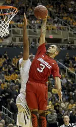 Louisville's Peyton Siva (3) goes up for a basket attempt over West Virginia's Kevin Jones.