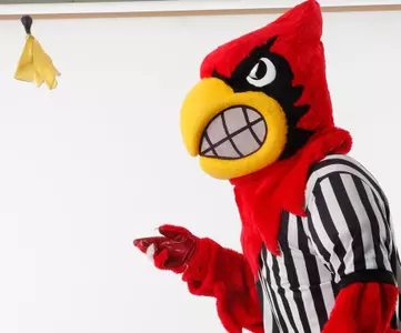 Louie throwing flag in referee outfit. | Compliance.