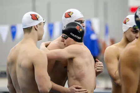 Zach Harting hugs his teammates after the relay