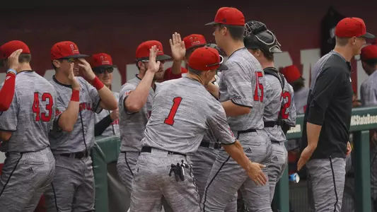 Teammates high five Bobby Miller heading into the dugout at NC State.