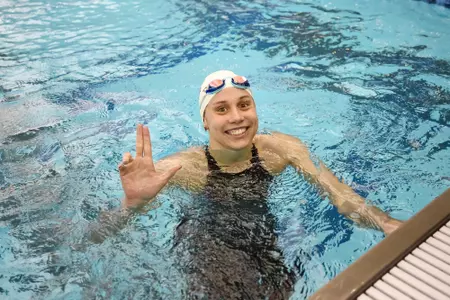 Mallory Comerford flashes the L sign at the wall.
