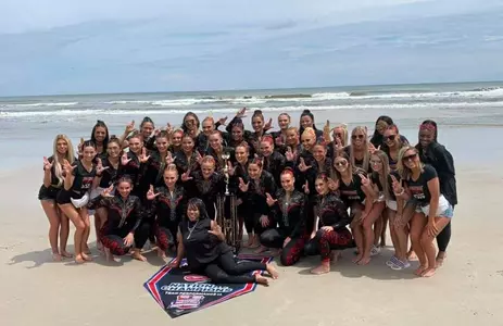 Ladybirds pose on the beach with their national championship trophy