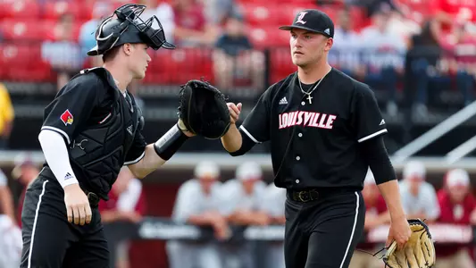 Reid Detmers gives Henry Davis a fist bump after retiring the side during game one in the series against Florida State.