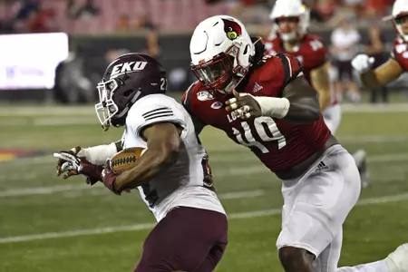 Louisville linebacker Boosie Whitlow (49) grabs Eastern Kentucky running back Daryl McCleskey Jr. (22) during the second half of an NCAA college football game in Louisville, Ky., Saturday, Sept. 7, 2019. (AP Photo/Timothy D. Easley)